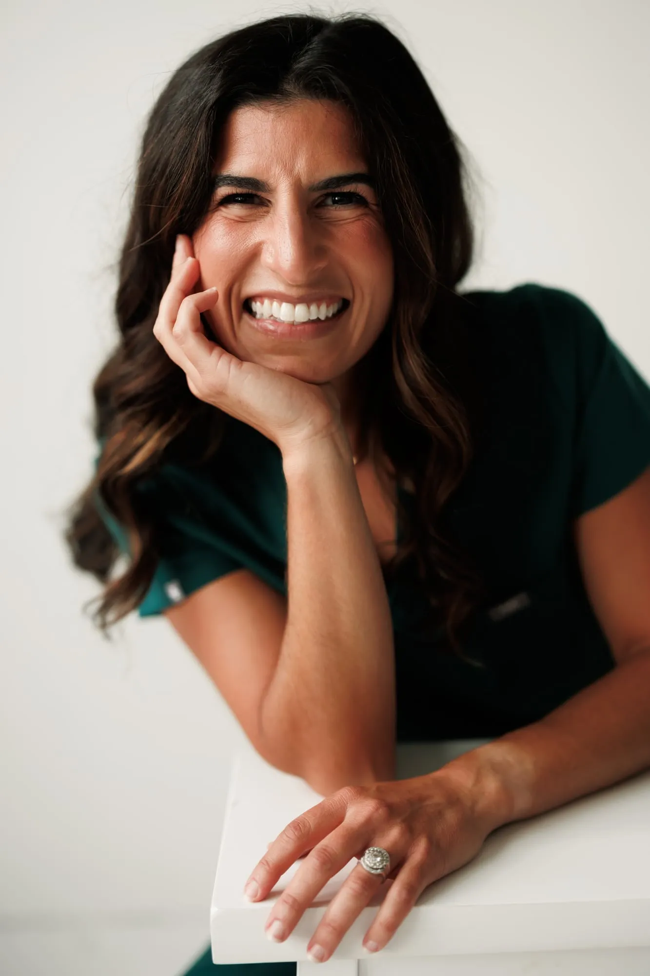 Dr. Caris Miller resting her chin on her hand with a big smile